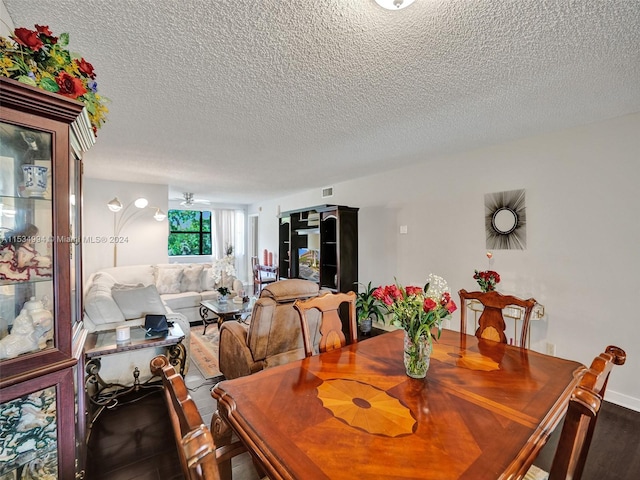 dining space featuring a textured ceiling and wood-type flooring