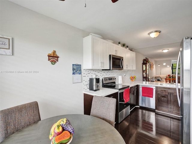 kitchen featuring ceiling fan, dark hardwood / wood-style flooring, appliances with stainless steel finishes, backsplash, and white cabinetry