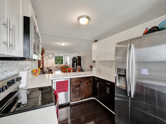 kitchen featuring tasteful backsplash, dark hardwood / wood-style flooring, appliances with stainless steel finishes, and kitchen peninsula