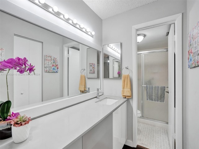 bathroom featuring toilet, an enclosed shower, tile flooring, a textured ceiling, and vanity