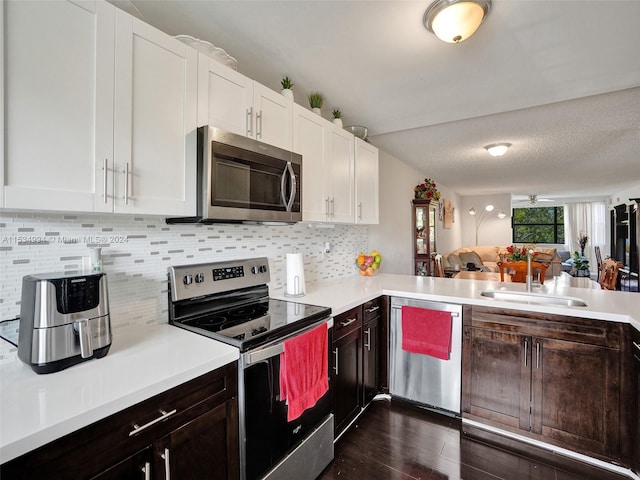 kitchen with white cabinets, stainless steel appliances, dark wood-type flooring, tasteful backsplash, and dark brown cabinetry