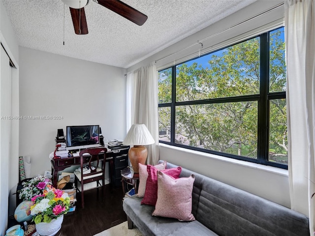 sitting room with hardwood / wood-style floors, a textured ceiling, and ceiling fan