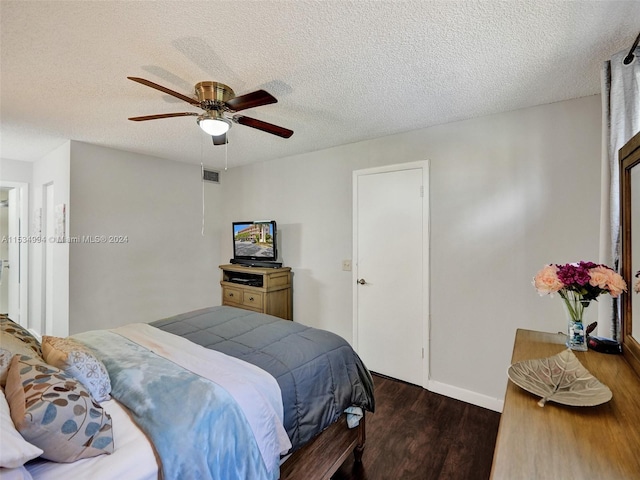 bedroom featuring a textured ceiling, ceiling fan, and dark hardwood / wood-style floors