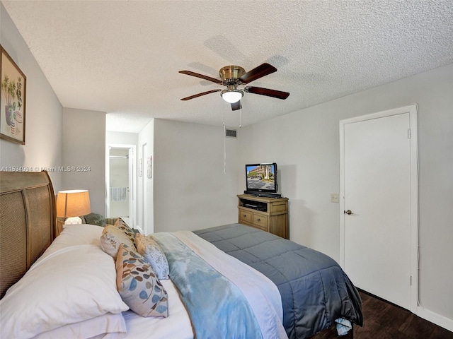 bedroom with a textured ceiling, ceiling fan, and dark wood-type flooring