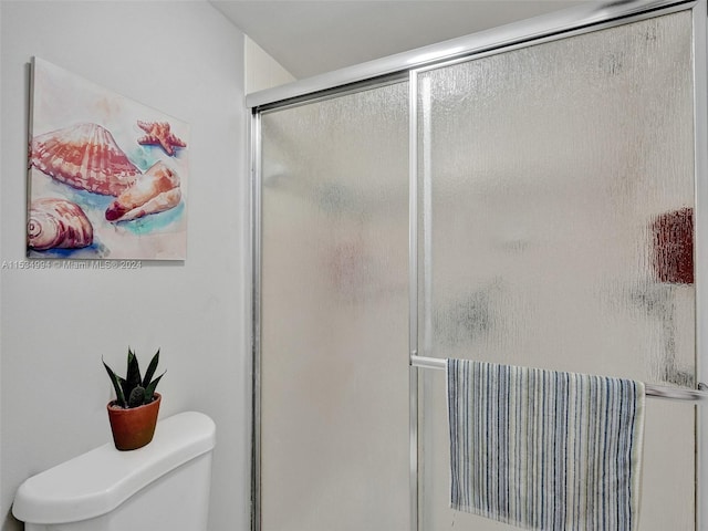 bathroom featuring an enclosed shower and toilet