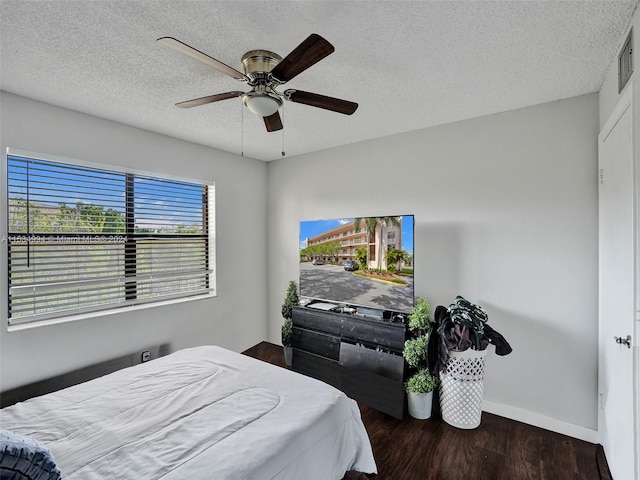 bedroom featuring a textured ceiling, ceiling fan, and dark wood-type flooring