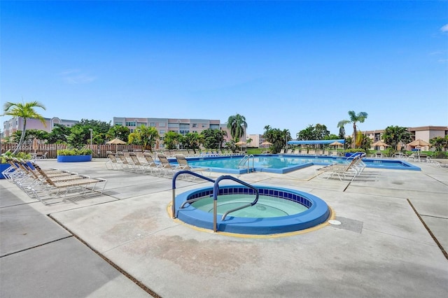 view of swimming pool with a community hot tub and a patio area