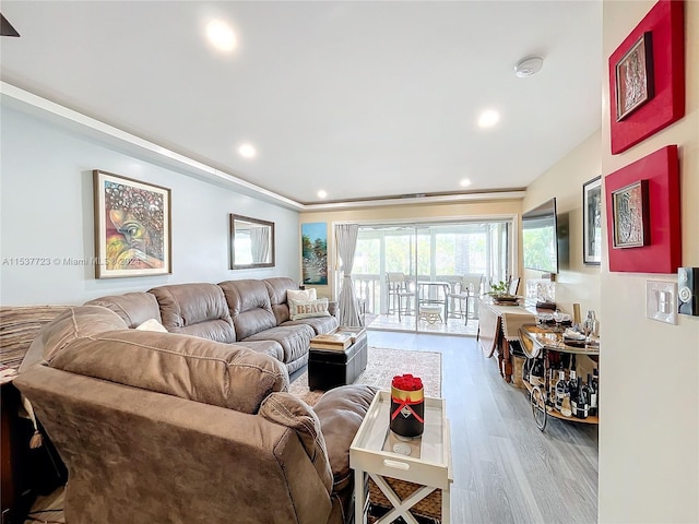 living room featuring wood-type flooring and ornamental molding