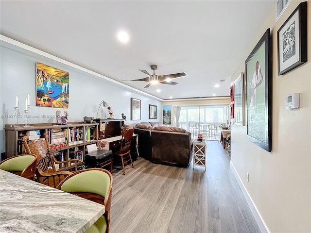 interior space with light wood-type flooring, ceiling fan, and crown molding