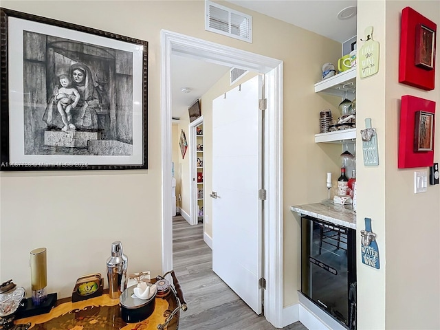 interior space featuring beverage cooler and light hardwood / wood-style floors