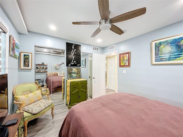 bedroom with a closet, light hardwood / wood-style floors, and ceiling fan