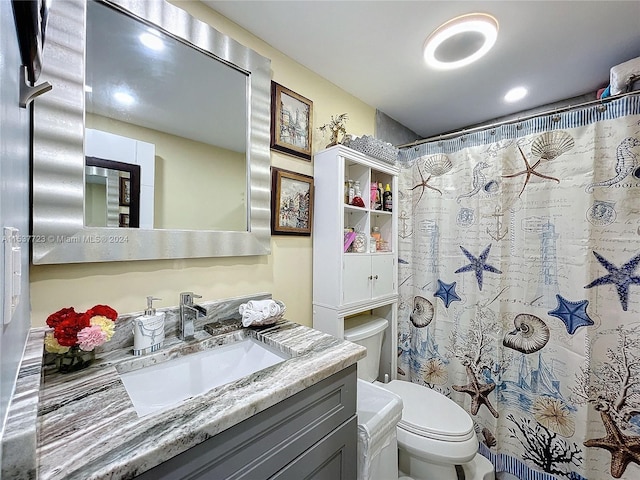 bathroom featuring curtained shower, vanity, and toilet