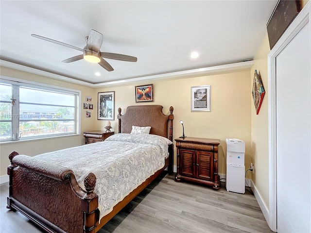 bedroom featuring light hardwood / wood-style floors, ceiling fan, and crown molding