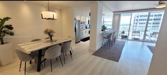 dining area with floor to ceiling windows, sink, ceiling fan, and light hardwood / wood-style flooring