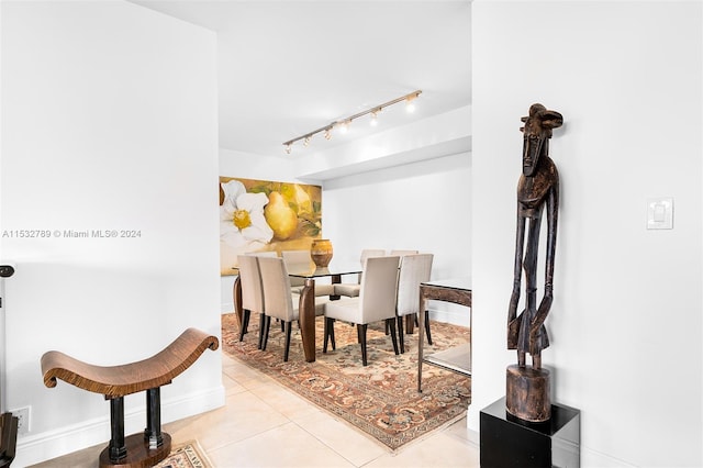 dining room featuring rail lighting and light tile flooring