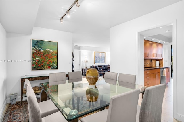 dining space featuring light tile flooring, rail lighting, and sink