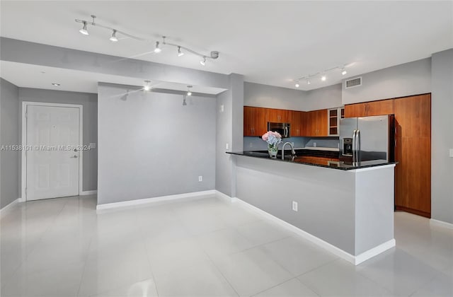 kitchen with rail lighting, stainless steel appliances, and light tile flooring