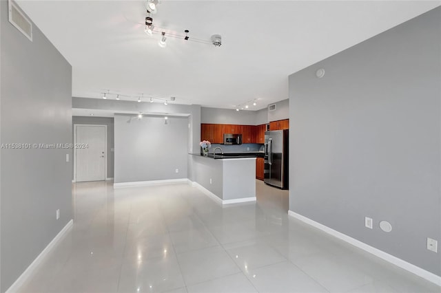 kitchen featuring light tile floors, appliances with stainless steel finishes, track lighting, and sink