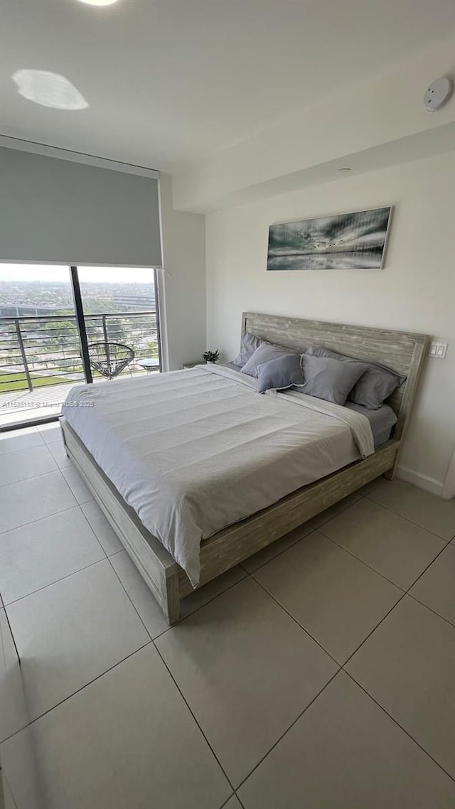 bedroom featuring tile patterned flooring, access to exterior, and baseboards