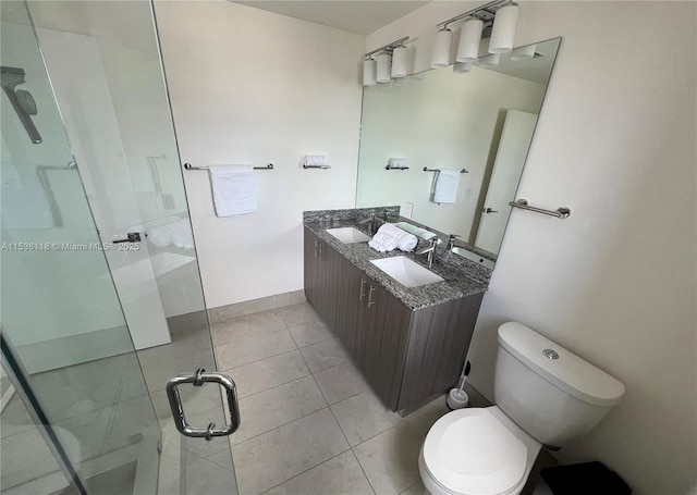 full bath featuring toilet, a stall shower, a sink, and tile patterned flooring