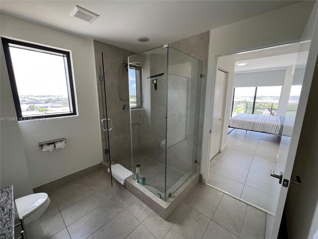ensuite bathroom featuring visible vents, a shower stall, and tile patterned flooring