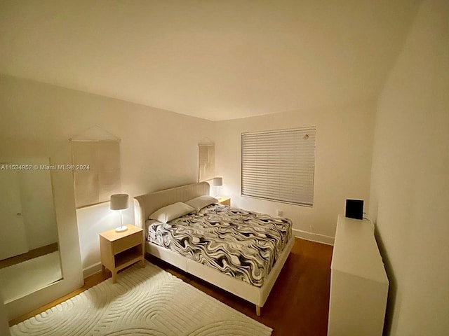 bedroom with dark hardwood / wood-style flooring