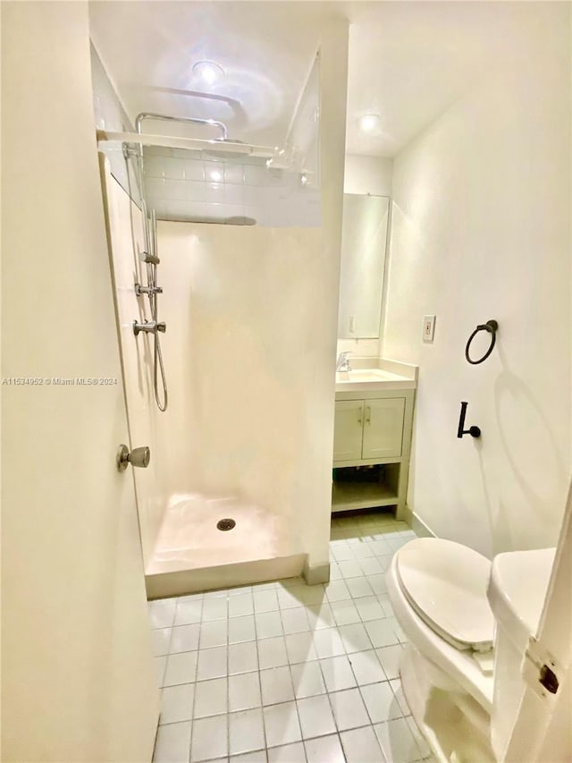 bathroom featuring tile patterned floors, a shower, vanity, and toilet