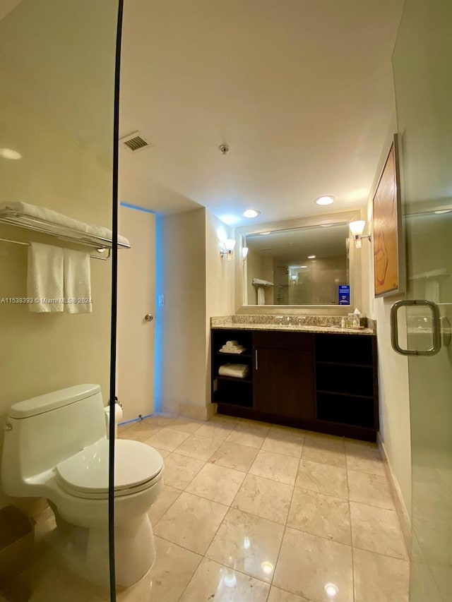 bathroom featuring vanity, tile patterned floors, a shower with door, and toilet