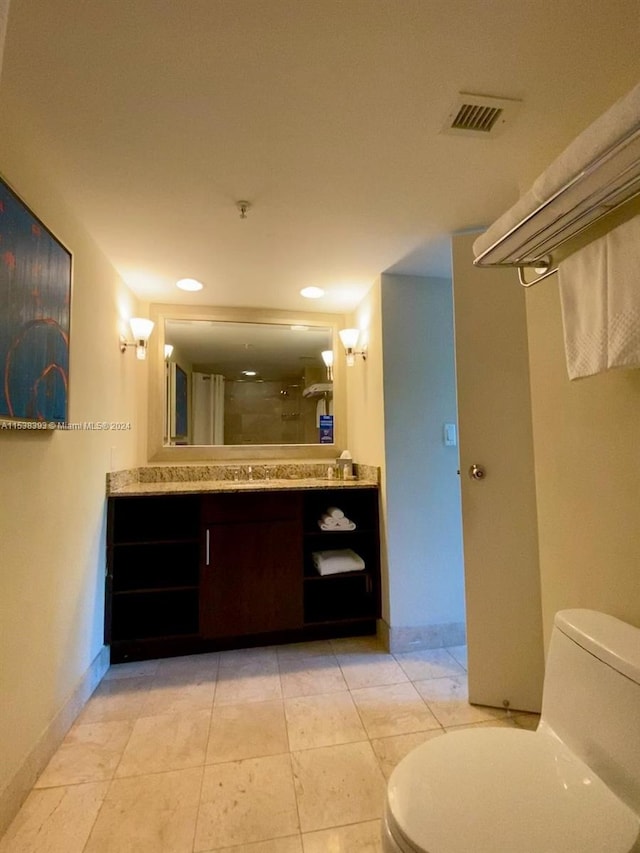 bathroom featuring a shower with door, vanity, tile patterned flooring, and toilet