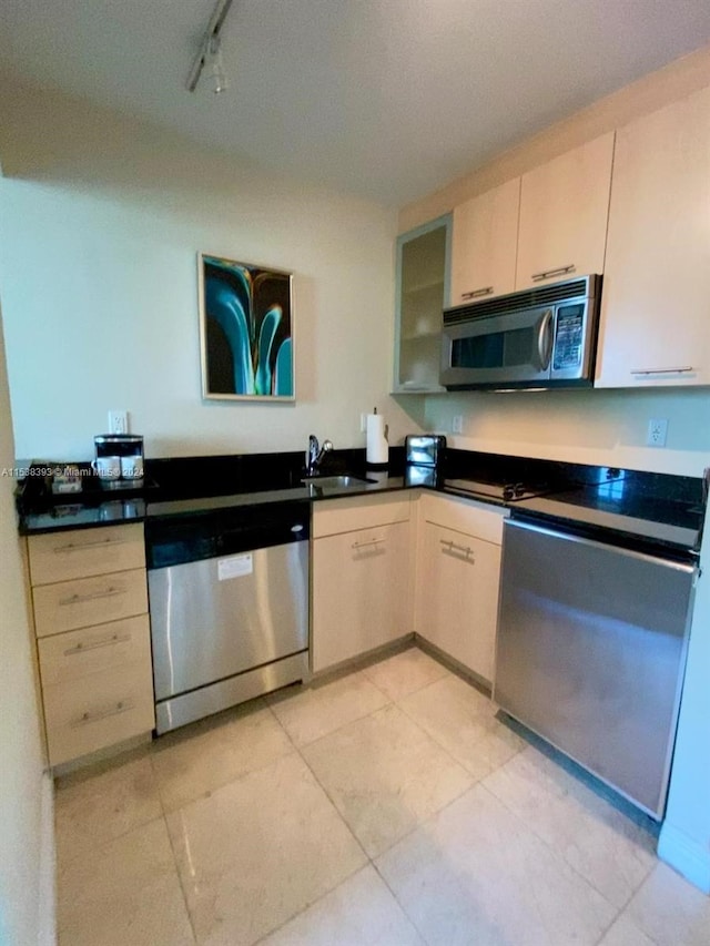 kitchen with appliances with stainless steel finishes, sink, and light brown cabinets