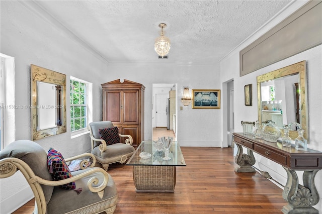 living area featuring a textured ceiling, dark hardwood / wood-style flooring, plenty of natural light, and crown molding