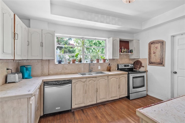 kitchen featuring backsplash, a raised ceiling, sink, light hardwood / wood-style floors, and stainless steel appliances