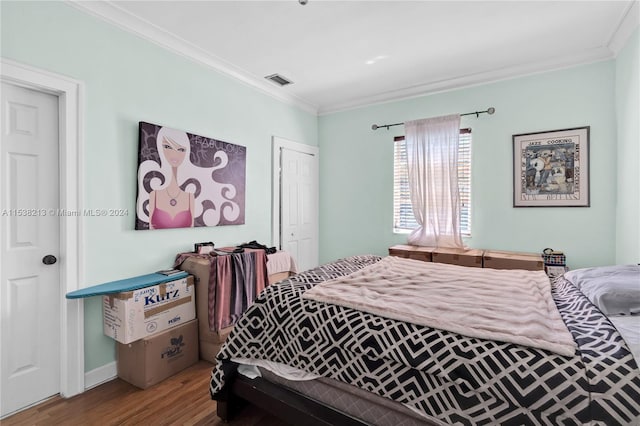 bedroom featuring a closet, ornamental molding, and hardwood / wood-style flooring