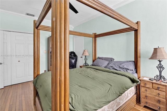 bedroom featuring ceiling fan, a closet, hardwood / wood-style flooring, and ornamental molding