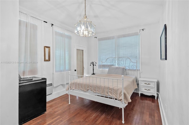 bedroom with hardwood / wood-style flooring and an inviting chandelier