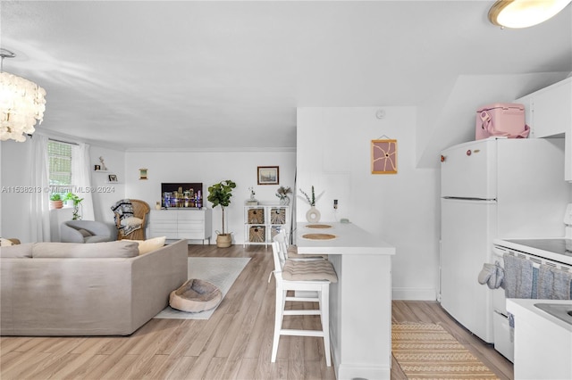 kitchen featuring a kitchen breakfast bar, ornamental molding, white range oven, light hardwood / wood-style flooring, and white cabinetry