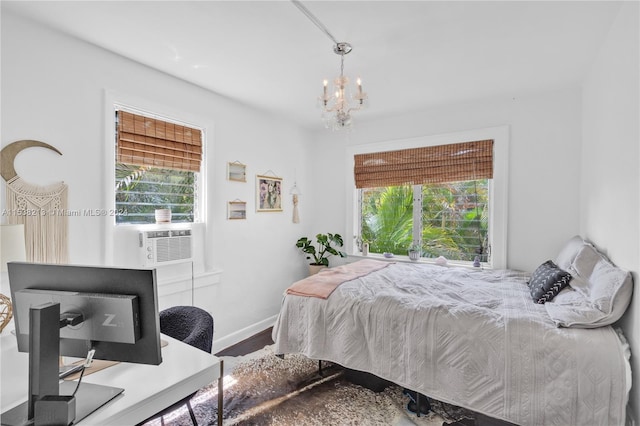 bedroom with hardwood / wood-style flooring, an inviting chandelier, and cooling unit