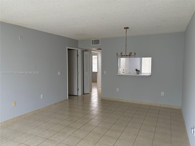 12755 SW 16th Ct Unit 211B, Pembroke Pines, FL 33027 - spare room featuring a chandelier, a textured ceiling, and light tile patterned floors