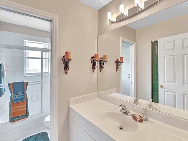 bathroom with bath / shower combo with glass door, vanity, and toilet