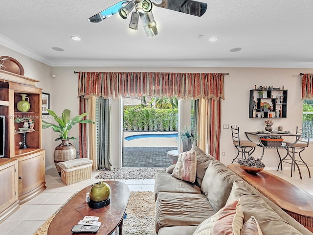 living room featuring ceiling fan, ornamental molding, a textured ceiling, and light tile patterned flooring