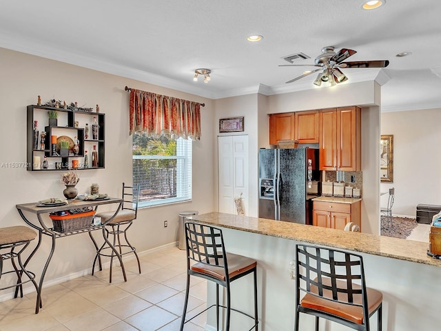 kitchen featuring visible vents, black fridge with ice dispenser, ornamental molding, light stone countertops, and backsplash