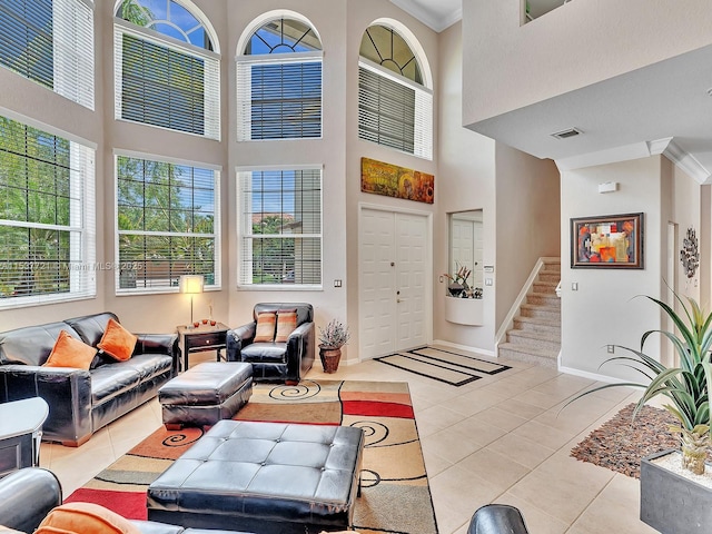 living area with stairs, visible vents, ornamental molding, and light tile patterned flooring