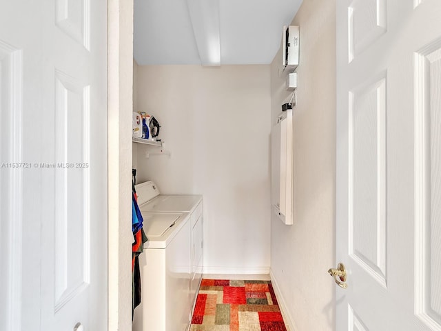 clothes washing area with laundry area, baseboards, and washer and clothes dryer