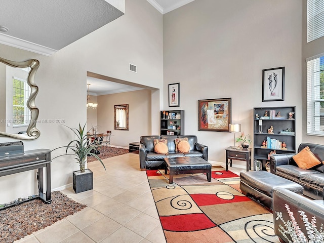 living room with light tile patterned floors, crown molding, a towering ceiling, visible vents, and an inviting chandelier