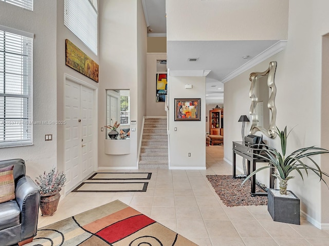 entryway featuring light tile patterned floors, stairs, visible vents, and crown molding