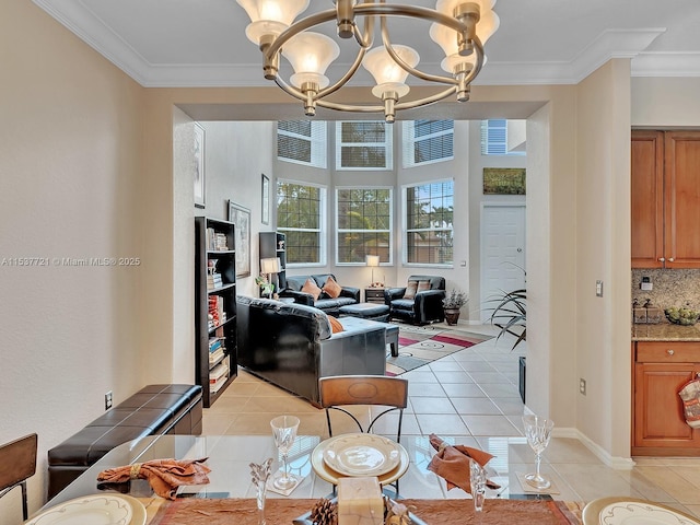 dining area with a notable chandelier, baseboards, crown molding, and light tile patterned flooring