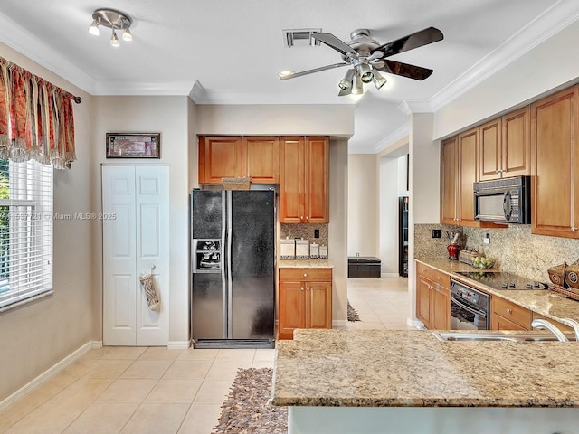 kitchen featuring light tile patterned floors, visible vents, light stone countertops, crown molding, and black appliances