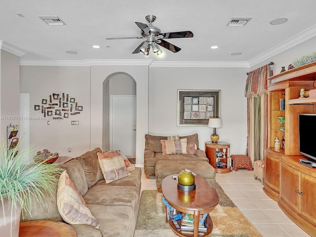 living room with arched walkways, light tile patterned floors, visible vents, and crown molding