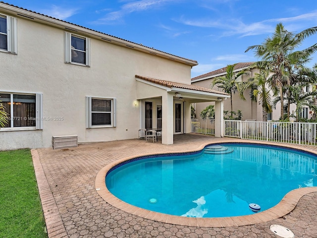 view of swimming pool with ceiling fan, a patio area, fence, and a fenced in pool