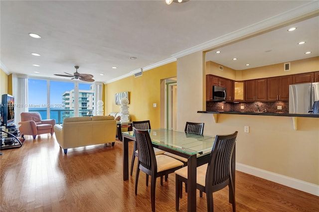 dining space with ornamental molding, ceiling fan, and hardwood / wood-style floors